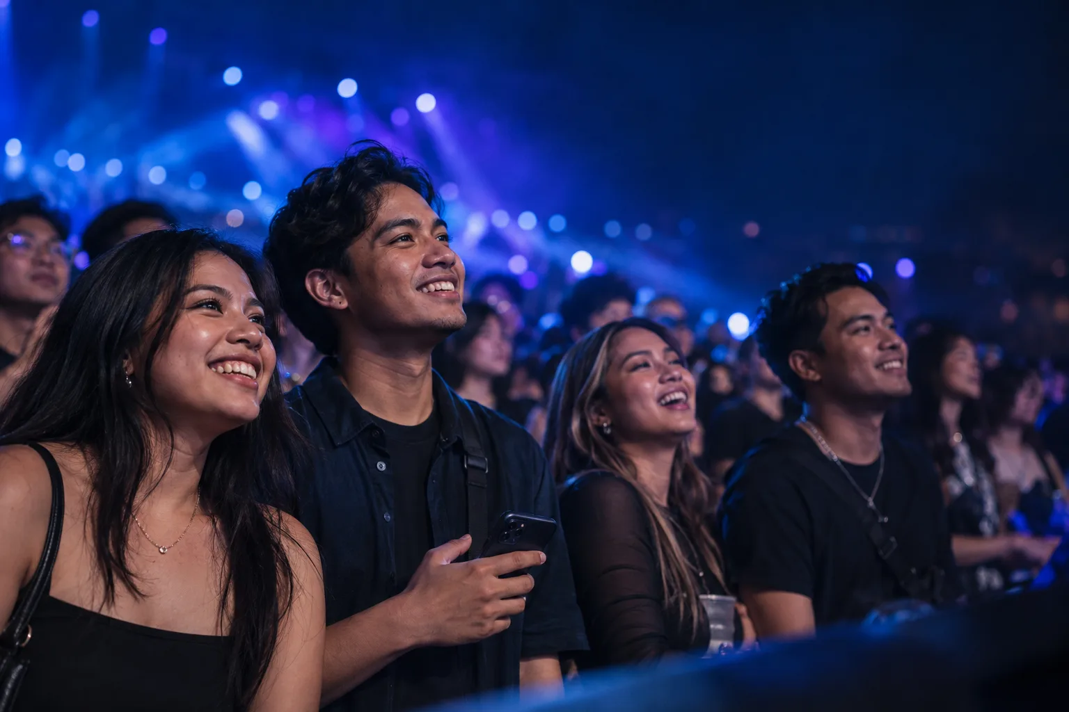 Friends enjoying a live event under blue and violet venue lights